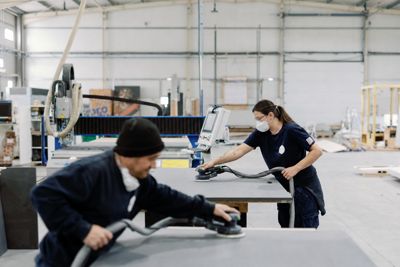 Two technicians collaboratively finishing a large panel